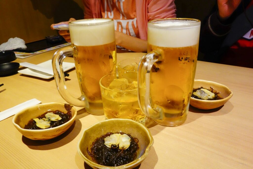 居酒屋のテーブルに並ぶビールとウーロン茶